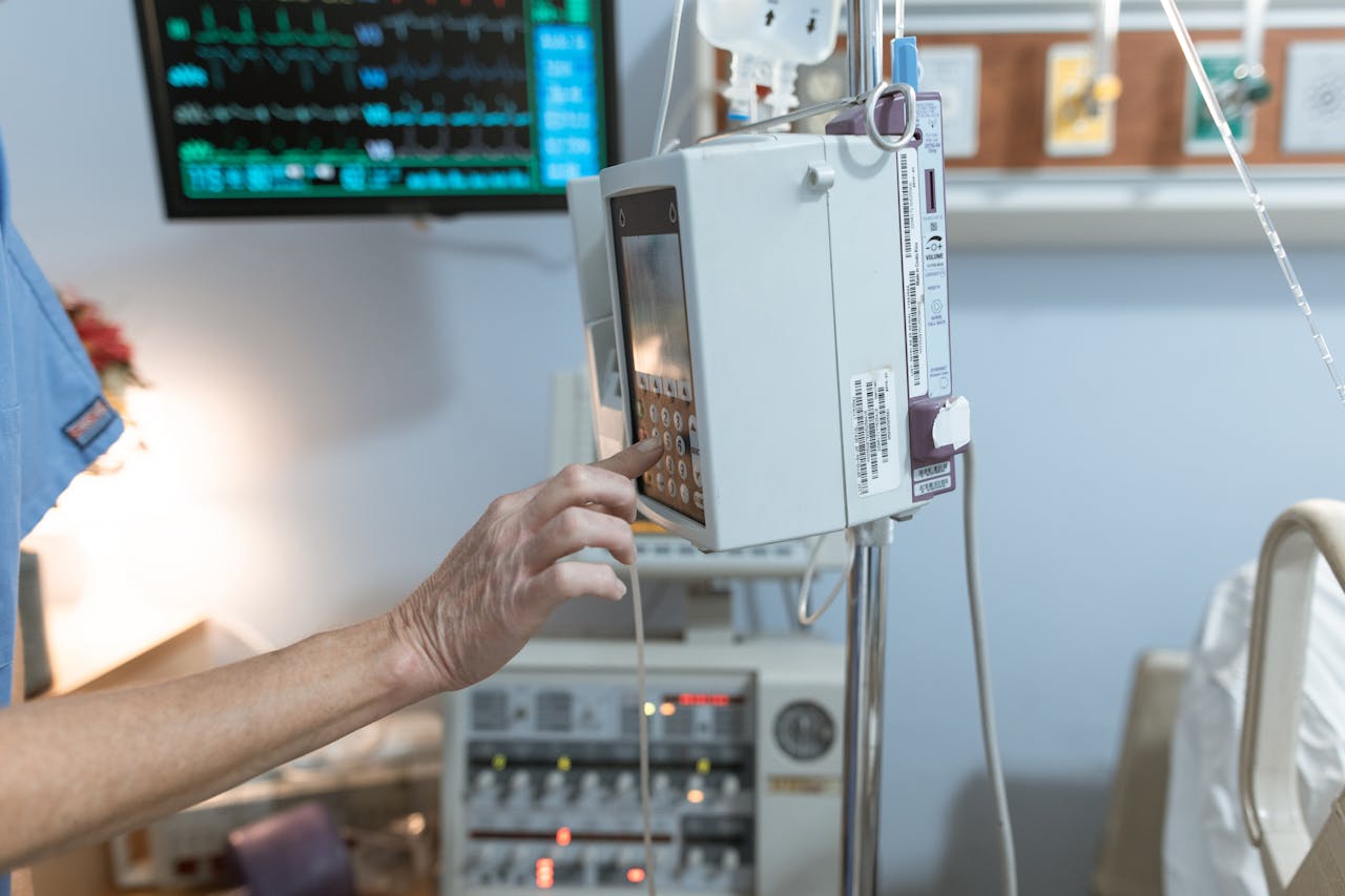 A healthcare worker operates a modern infusion pump in a hospital setting, ensuring precise medication delivery.